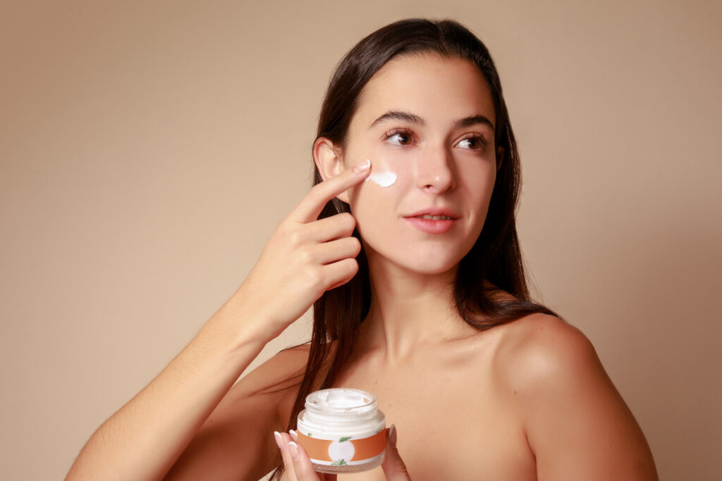 Joven Mujer mexicana aplicando crema humectante facial producto de belleza