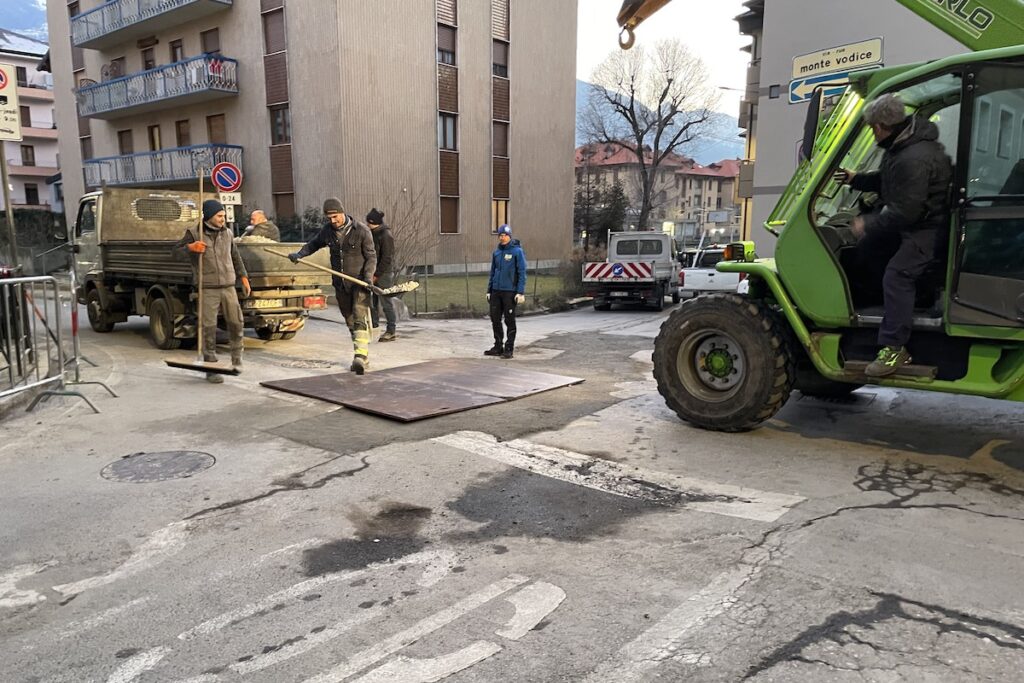 Operai al lavoro sulla buca apertasi in via Monte Vodice, ad Aosta