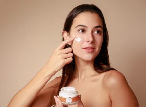 Joven Mujer mexicana aplicando crema humectante facial producto de belleza