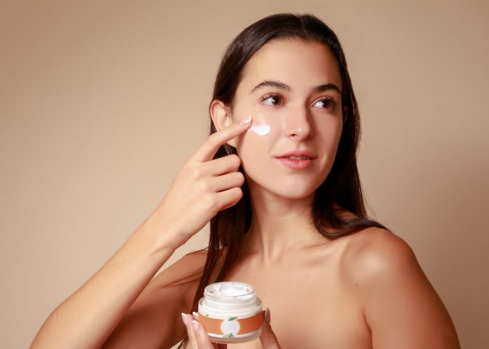 Joven Mujer mexicana aplicando crema humectante facial producto de belleza