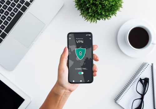 Young woman holding and using smartphone with vpn app