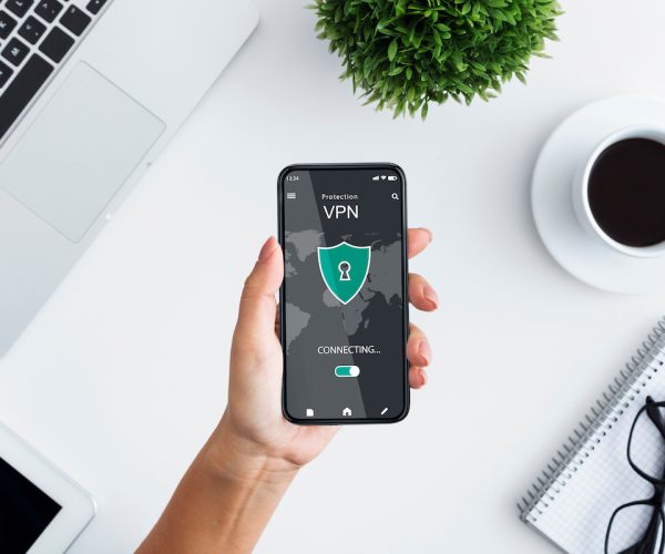 Young woman holding and using smartphone with vpn app