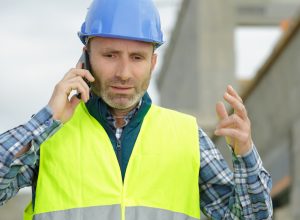 stressed workman gesturing during telephone conversation