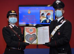 Due militari del Gruppo Aosta mostrano il calendario.