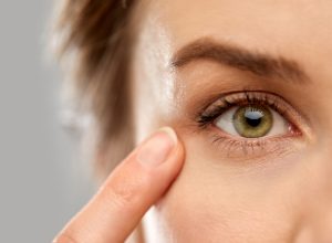 close up of woman pointin finger to eye