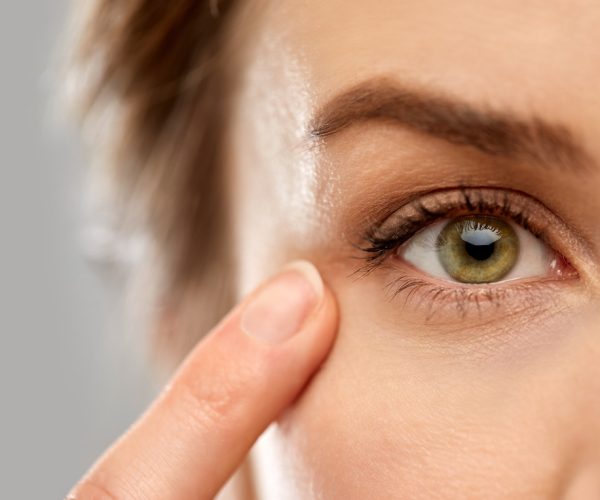 close up of woman pointin finger to eye