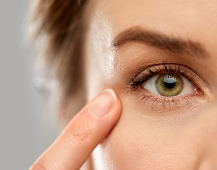 close up of woman pointin finger to eye