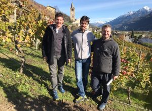 Da sinistra Hervé e Simon Grosjean con Rudy Sandi ampelografo nella Vigna Merletta con alle spalle la chiesa di Saint Christophe