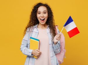 Young surprised excited cool black teen girl student she wearing casual clothes backpack bag hold books french flag isolated on plain yellow color background High school university college concept
