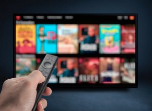 Tv online Television streaming video Male hand holding TV remote control Multimedia streaming concept VoD content provider Video service with internet streaming multimedia shows, series