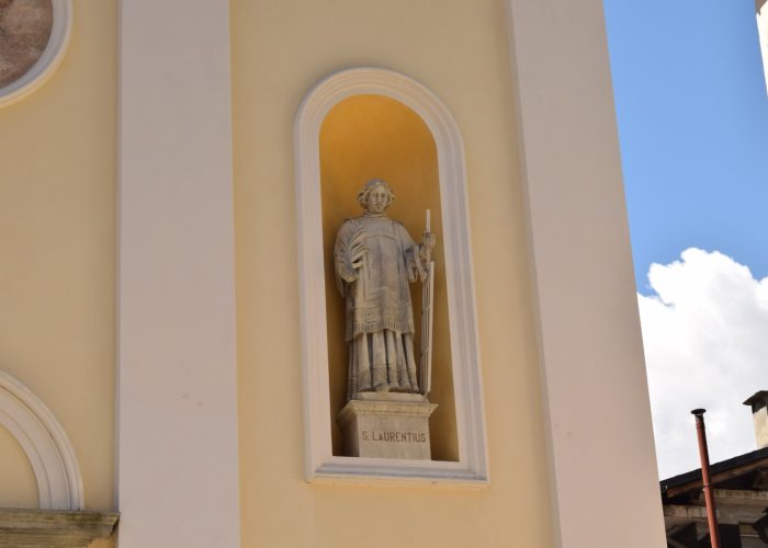La statua di San Lorenzo nella facciata della Chiesa di Pont-Saint-Martin