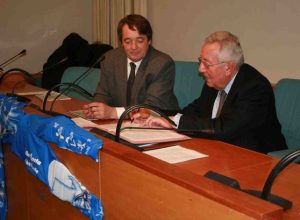 La firma dell'Accordo tra Pastoret (sx) e Bolognini (dx), al centro la tuta sponsorizzata VdA