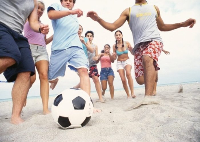 adolescenti giocano a palla in spiaggia, giovani